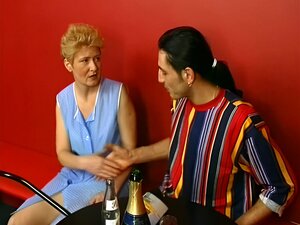Vieille dame blonde d'Allemagne frappant dans le bar
