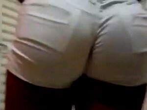 Une mignonne noire avec un joli cul taquine en short