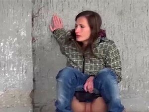 Brune chaude pissant sur un banc dans un parc. La mignonne brune