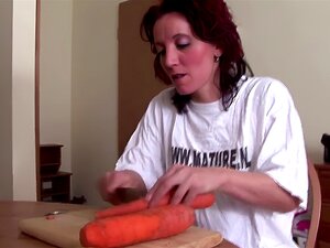 La belle-mère plus âgée se baise la chatte avec une carotte et