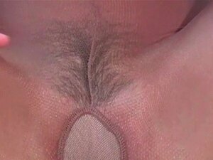 Insertion d'un gode en verre. Une jolie nana en collants noirs lui