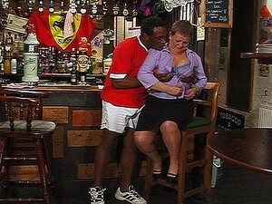 Une barmaid plus âgée prend sa bouteille longue aussi profondément