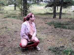 Une mignonne nana pisse dans la rue dans la forêt et montre ses