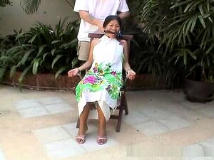 Bébé asiatique attirante attachée sur une chaise