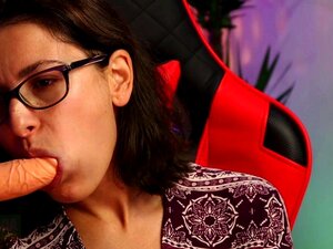 Femme à lunettes suçant un gode sensuellement